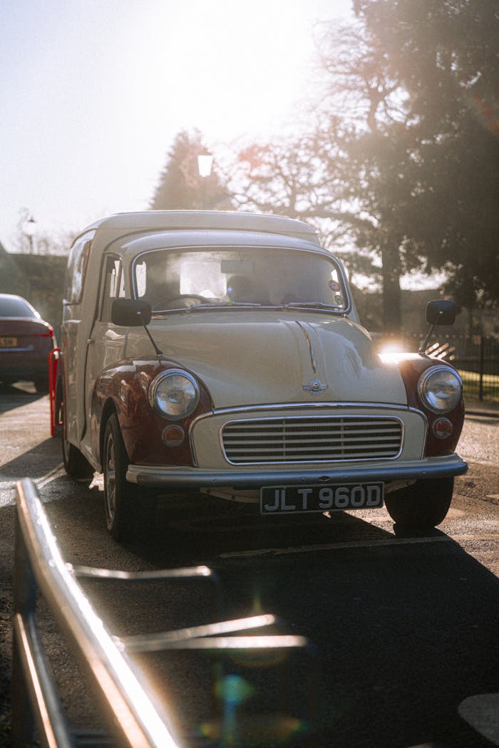 Classic car with license plate JLT 960D under bright sun on UK street.
